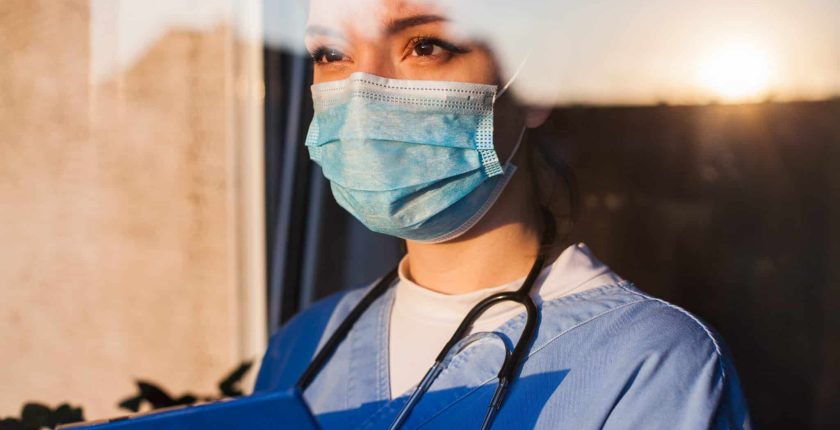 Sad Doctor standing at window
