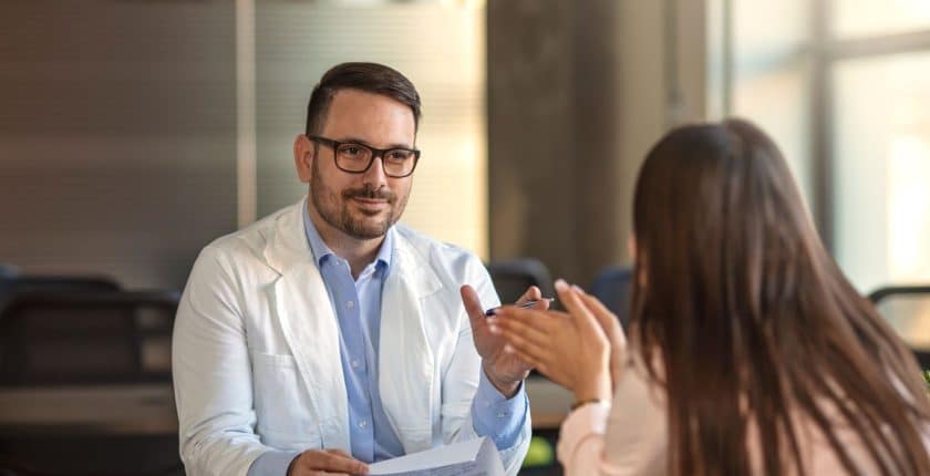 Doctor sitting across the desk from an employee